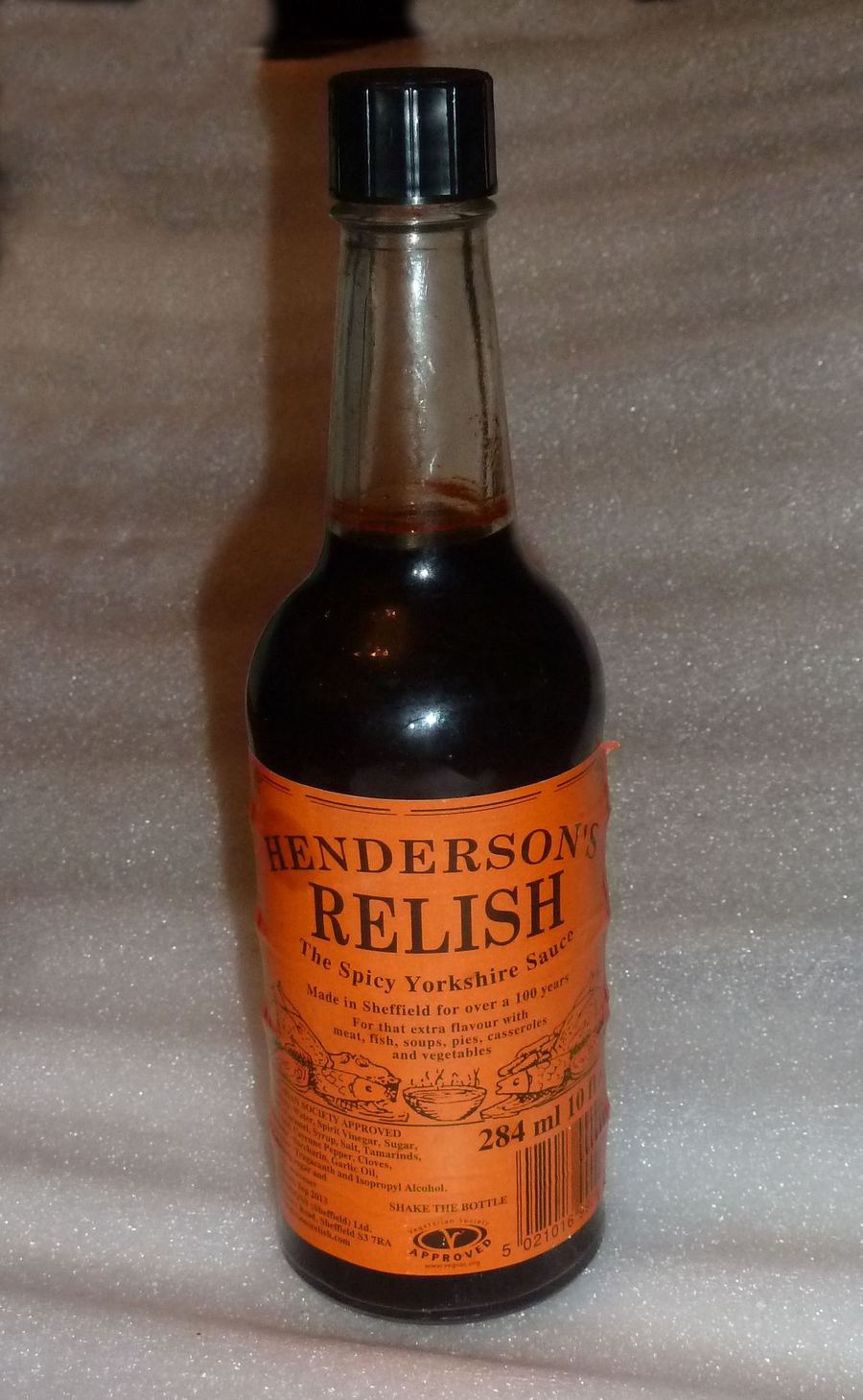 A bottle of Sheffield-brewed Henderson's Relish beside a pub meal.