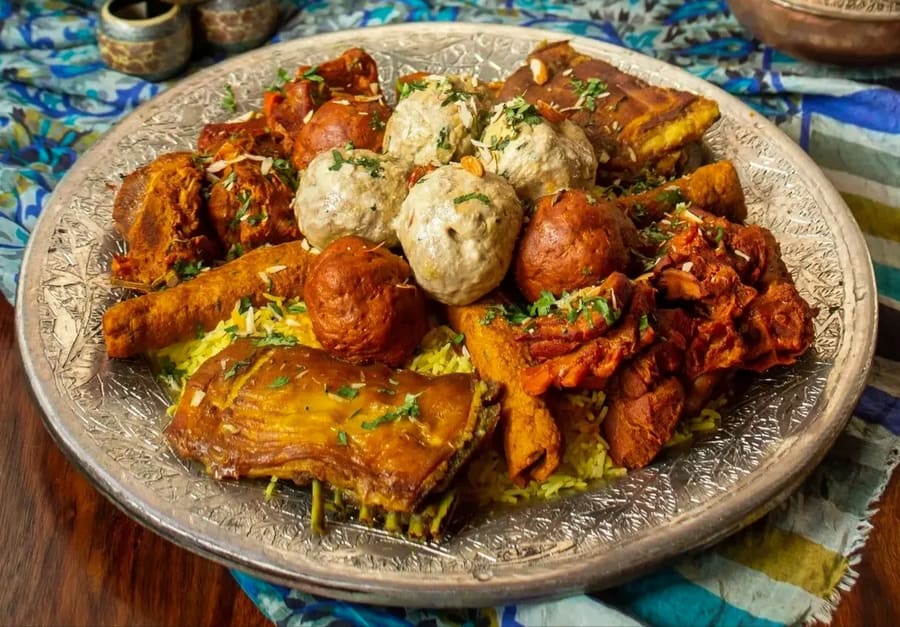 A traditional Wazwan platter featuring rista, rogan josh, and tabak maaz.