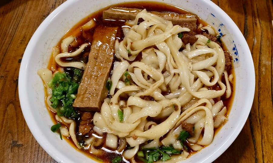 Daoxiao mian shaved straight into broth with braised pork and coriander.