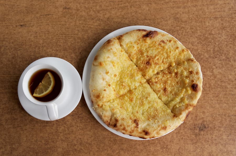 Adjaruli khachapuri served hot with butter and fresh egg yolk.