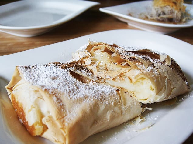 Freshly chopped cream bougatsa dusted with icing sugar and cinnamon.