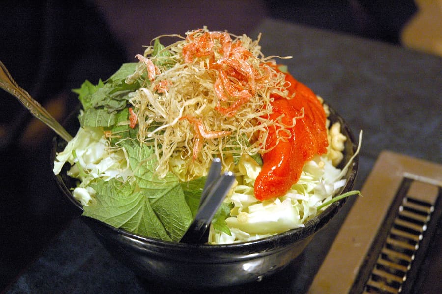 Monjayaki sizzling on a hot iron griddle in a Tsukishima restaurant.