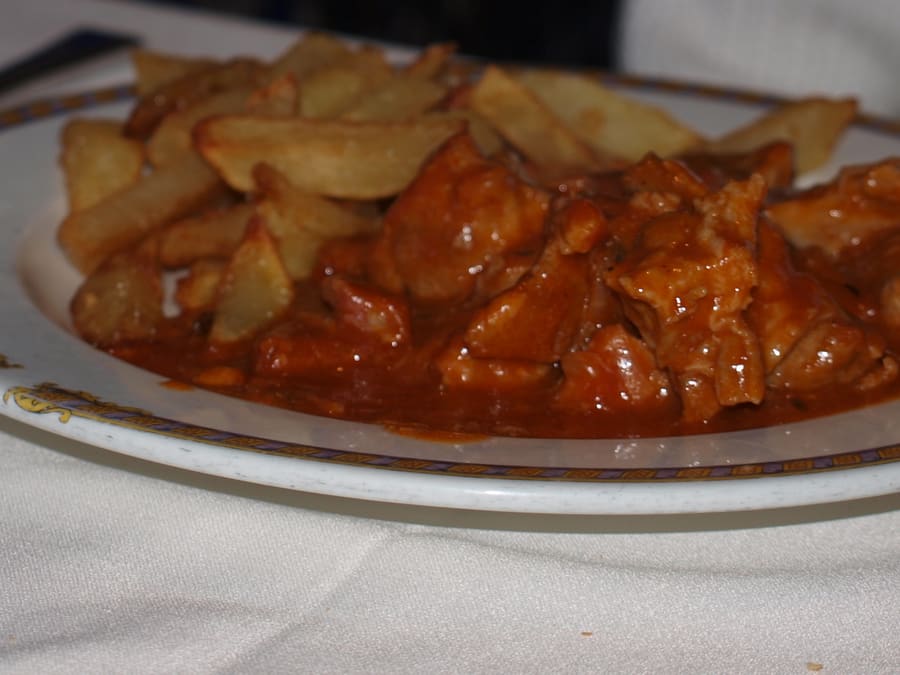 Carcamusa served in a clay pot with crusty bread.