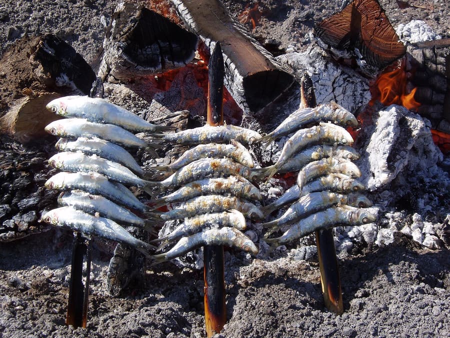 Sardines skewered on bamboo and roasted over olive-wood fires in beach sand pits.