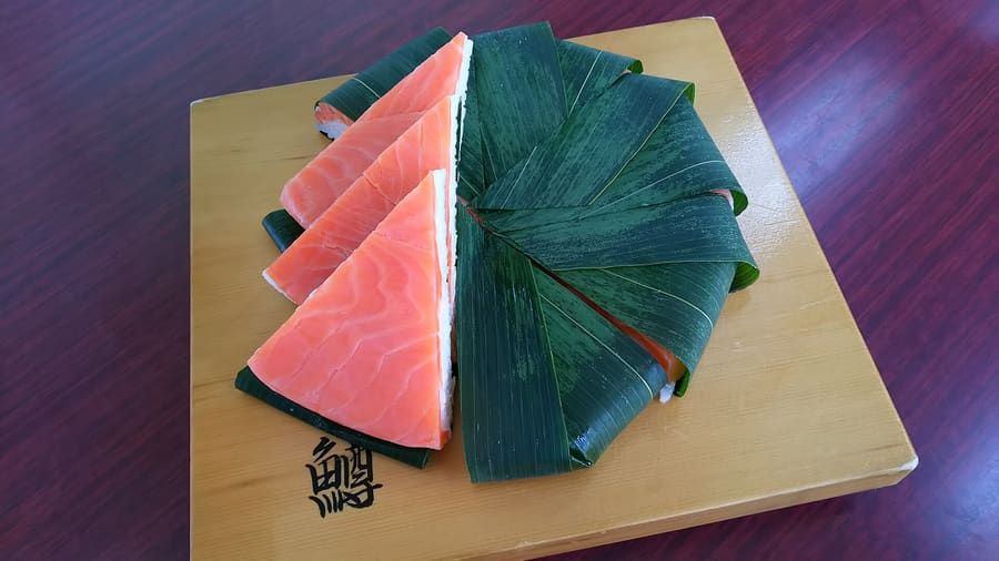 Masuzushi, vinegared trout pressed with rice inside bamboo leaves.