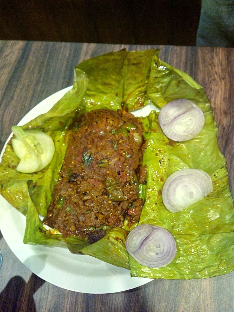 Karimeen pollichathu, fresh lake fish marinated in spice paste and grilled inside a banana leaf.