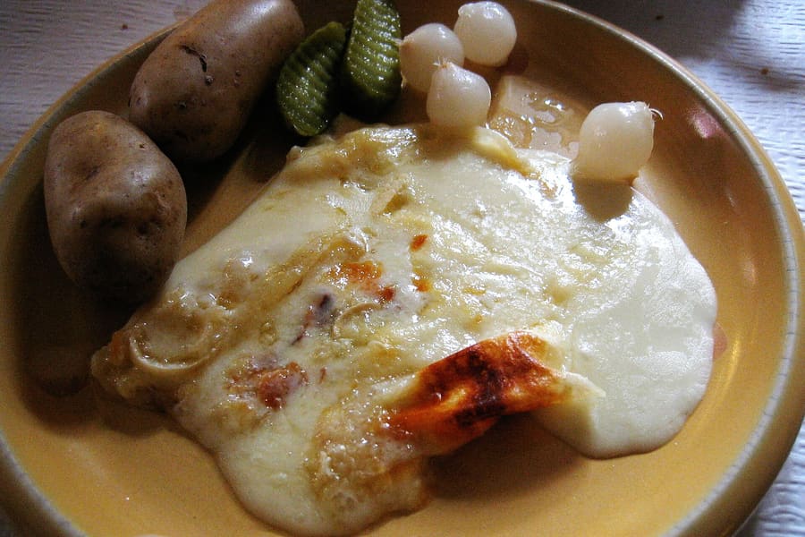 Raclette scraped fresh from a wheel of Valais AOP cheese.