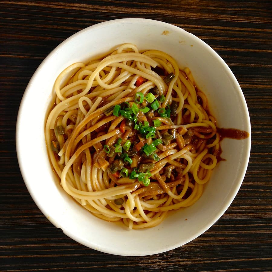Hot dry noodles mixed with sesame paste at a neighborhood breakfast stall.